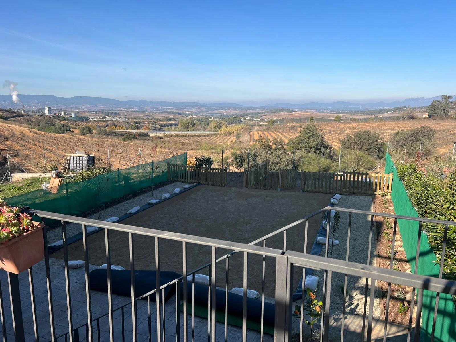 Després (desembre 2025): jardí després de la instal·lació de gespa artificial, amb acabat verd uniforme i net