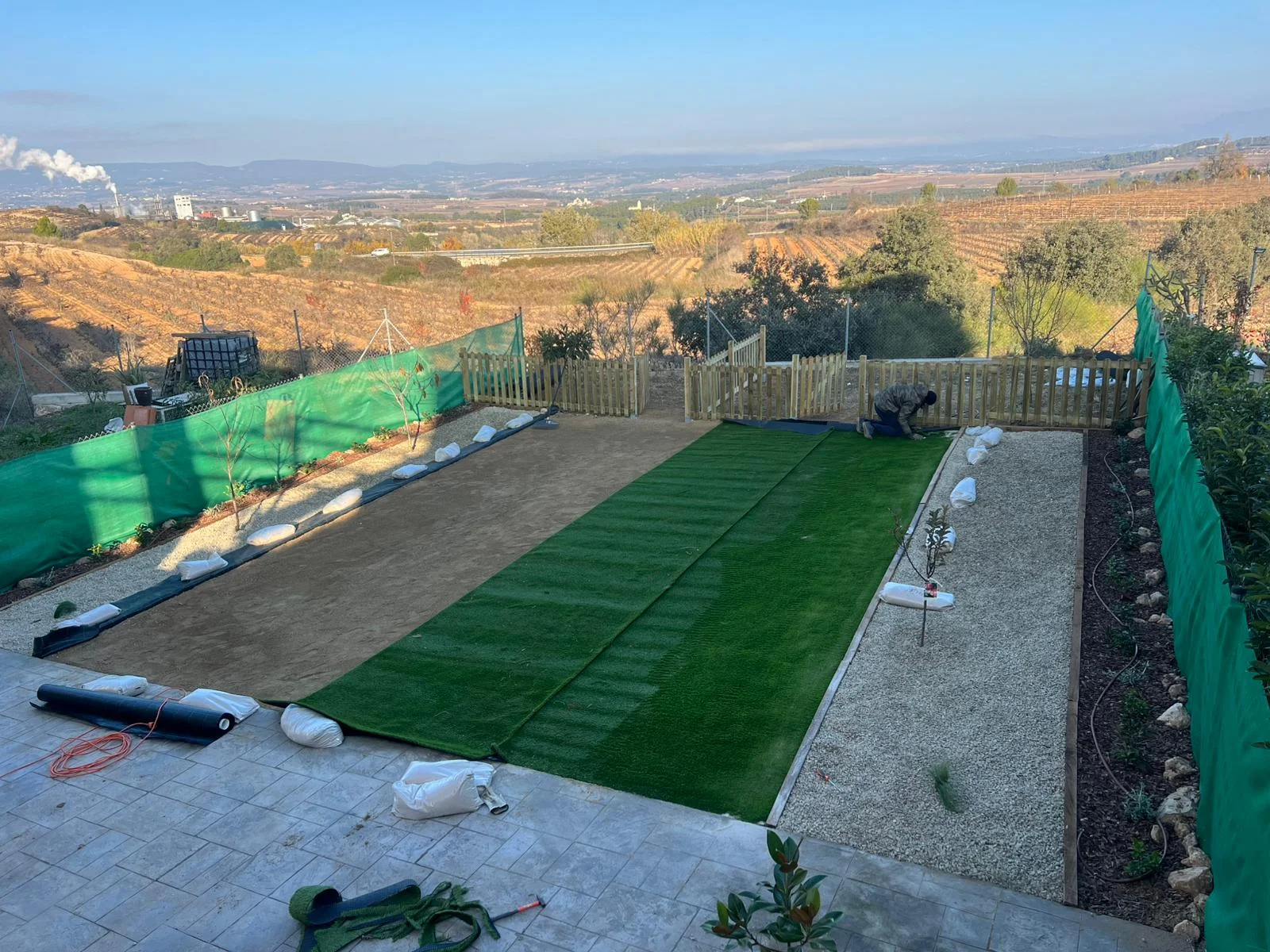 Procés (desembre 2025): detall de la base compactada i la col·locació de peces de gespa artificial